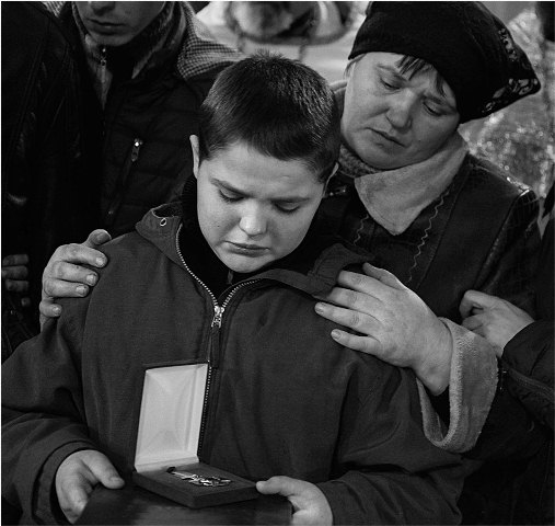 Син загиблого із батьківською нагородою. Фото Олександра Слєпцовського