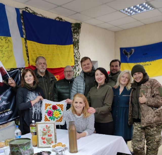 Волонтери центру і їхні друзі з Латвії: сидить Любов Терещенко, вишиту подушечку тримають колишня працівник страхового агентства і волонтер Оксана Благірєва (праворуч) та волонтер з Латвії Вайра Лейніце