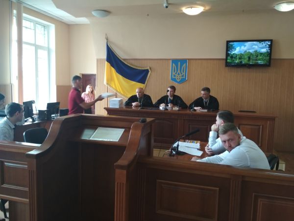 Слідчий кладе на стіл перед суддею томи написаної справи по Дмитру Кухарчуку