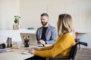 two-business-people-with-wheelchair-in-the-office-PAENSYL-min-e1594731602685