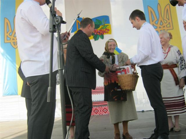 Марії Вівчарик вручають подарунки і диплом переможця