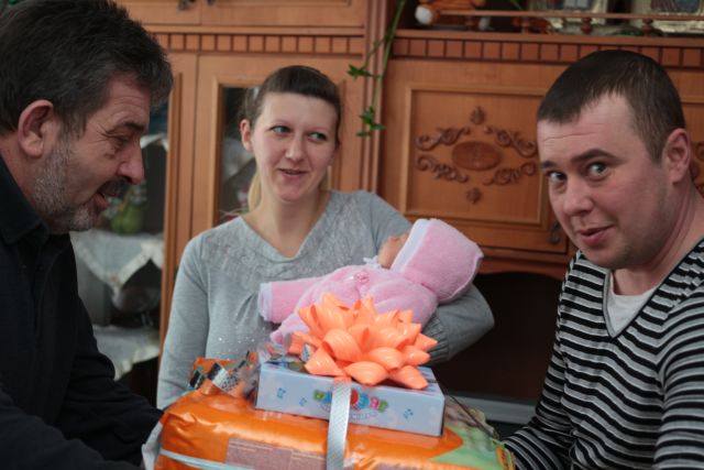 Володимир Братаніч тримає на руках маленьку Заріну. Принагідно батькам дівчинки голова сільської ради Алла Бусля також вручила свідоцтво про народження