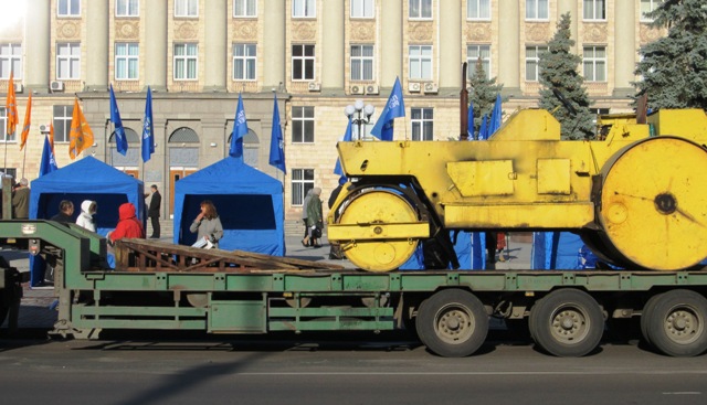 Перед наметами вздовж дороги стояв причеп, на якому хтось завбачливо розташував каток. Очевидно, щоб мітинг не ранив душу пасажирів автобусів, що проїжджали мимо…