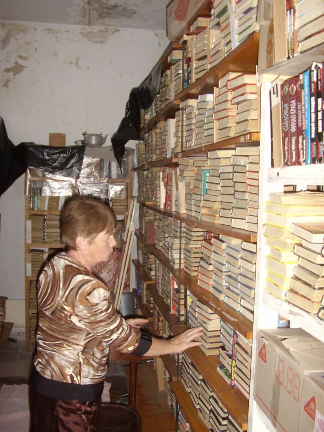 Завідуюча бібліотекою показує вже переставлені купками, а не в ряд, книги. Каже, що так на них менше утворюється моху.